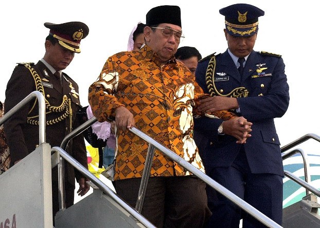 Seorang perwira militer membantu Abdurrahman “Gus Dur” Wahid yang saat itu menjabat sebagai Presiden Indonesia menuruni tangga pesawat setibanya di Jakarta, 29 Juni 2001. [AFP]