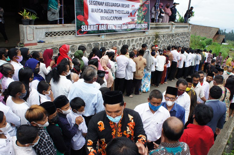 Warga berkumpul mengucapkan selamat Natal kepada rekan mereka yang merayakan di desa Thekelan di Semarang, Jawa Tengah pada 25 Desember 2021. [Daffa Ramya Kanzuddin/AFP]