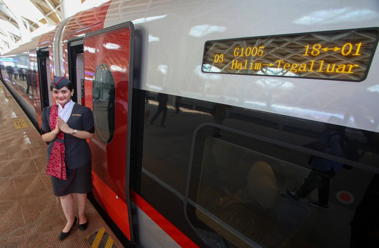 Seorang staf Kereta Cepat Jakarta-Bandung tersenyum menyambut para penumpang yang akan menguji coba kereta tersebut dalam perjalanan dari Jakarta menuju Bandung, di Stasiun Halim, Jakarta, 15 September 2023. [Eko Siswono Toyudho/BenarNews]