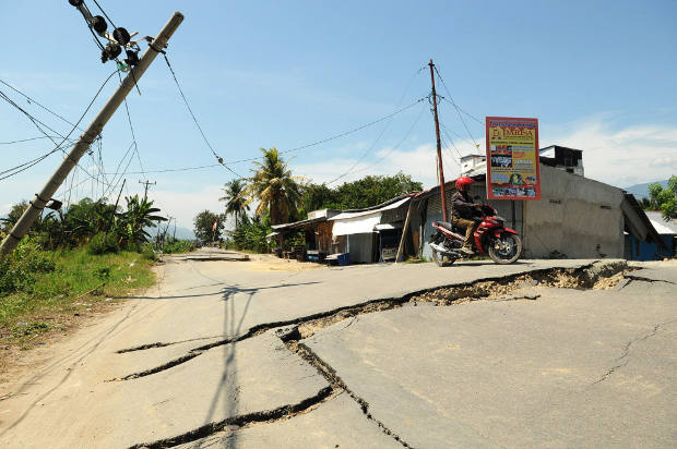 Seorang pengendara sepeda motor berusaha menghindar dari jalan yang hancur akibat gempa di Kabupaten Sigi, Sulawesi Tengah, 7 Oktober 2018. (Keisyah Aprilia/BeritaBenar)