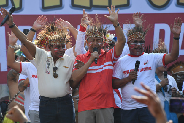Menko Polhukam Wiranto (tengah) bernyanyi bersama ratusan warga Papua dan warga Jakarta di ibu kota dalam acara musik dan tarian Yospan Papua di Bundaran Hotel Indonesia (HI), Jakarta, Minggu, 1 September 2019. (AFP)