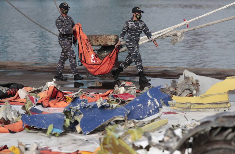 Tentara Angkatan Laut membawa kantong jenazah yang berisi potongan tubuh korban jatuhnya pesawat Sriwijaya Air SJ-di Pelabuhan Tanjung Priok, Jakarta, 21 Januari 2021. [AP]