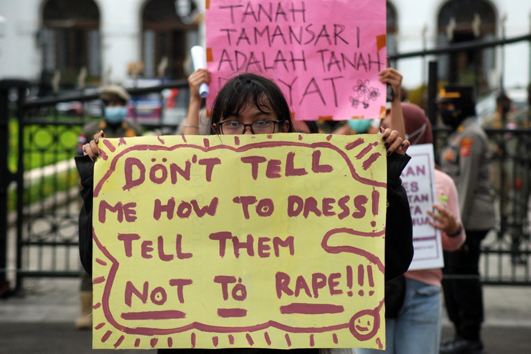 Seorang aktivis mengangkat poster dalam unjuk rasa memperingati Hari Perempuan Internasional di Bandung pada 8 Maret 2021. [Timur Matahari/AFP]