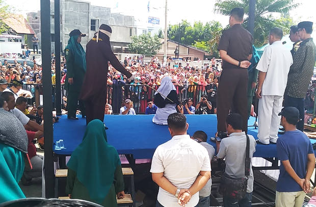 Ratusan warga menyaksikan pelaksanaan eksekusi cambuk di halaman sebuah masjid di Banda Aceh, 20 April 2018. (Nurdin Hasan/BeritaBenar)