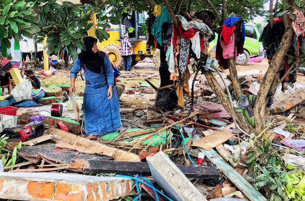 Seorang warga mengumpulkan pakaian yang masih bisa digunakan di Kecamatan Sumur, Kabupaten Pandeglang, Banten, 26 Desember 2018. (Keisyah Aprilia/Berita Benar) 