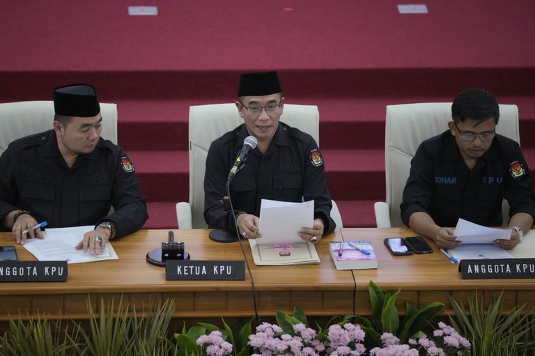 Hasyim Asy'ari, Ketua Komisi Pemilihan Umum (tengah), didampingi anggota KPU Mochammad Afifuddin (kiri) dan Idham Holik, mengesahkan hasil Pemilu 2024 di kantor KPU di Jakarta, 20 Maret 2024. [Dita Alangkara /AP]