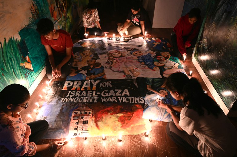 Anak-anak di India menyalakan lilin di untuk menyatakan simpati kepada para korban konflik yang sedang berlangsung antara Israel dan Hamas, di Mumbai pada 13 Oktober 2023. [Indranil Mukherjee/AFP]