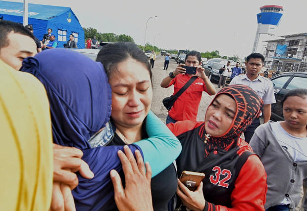 Putri (tengah, berbaju hitam) yang mengatakan bahwa suami dan anaknya berada di dalam pesawat naas Lion Air JT-610, dihibur di Pelabuhan Pangkal Pinang di Provinsi Kepulauan Bangka Belitung, 29 Oktober 2018. 