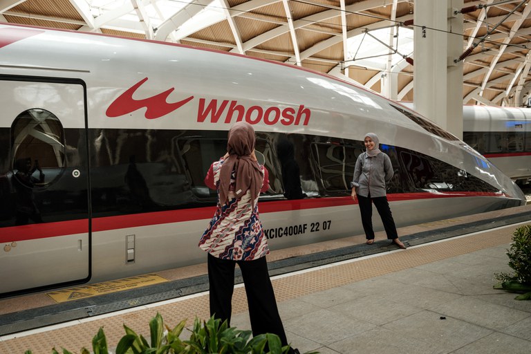Seorang warga berfoto di depan Kereta Cepat Jakarta-Bandung “Whoosh” proyek kerja sama Indonesia-China usai diresmikan di Stasiun Halim Jakarta pada 2 Oktober 2023. [Yasuyoshi Chiba/AFP]