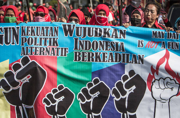 Sejumlah buruh perempuan membawa spanduk saat menggelar aksi peringatan Hari Buruh Sedunia di Jakarta, 1 Mei 2018. (Afriadi Hikmal/BeritaBenar)