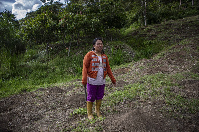 Asmarani Lacege mengenakan sepatu bot karet dan memegang parang sebelum memasuki perkebunan kakao miliknya di perbukitan Alitupu, Kecamatan Lore Utara, Kabupaten Poso, Provinsi Sulawesi Tengah, 19 Maret 2023. [Keisyah Aprilia/BenarNews]