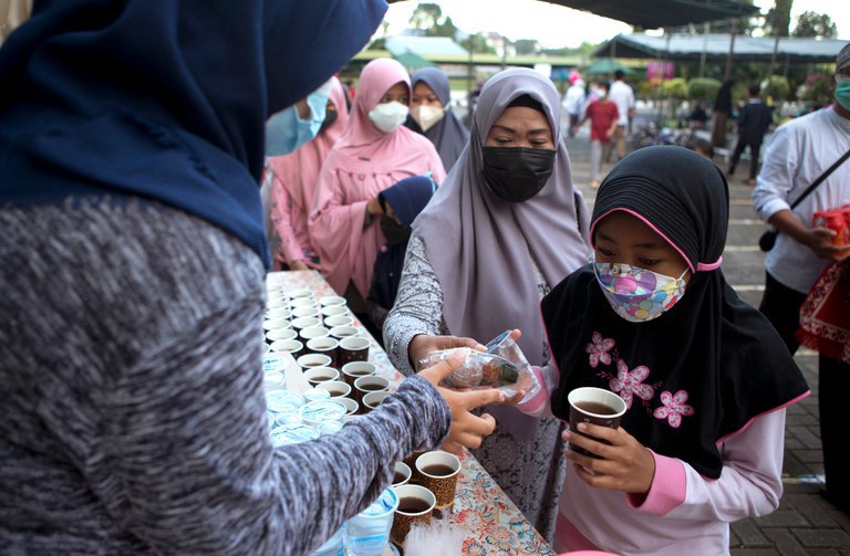 Kaum Muslimah menerima makanan dan minuman untuk berbuka puasa pada hari pertama Ramadan di sebuah masjid di Denpasar, Bali, 3 April 2022. [Firdia Lisnawati/AP Foto]