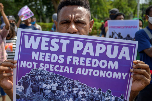 Membawa poster, mahasiswa Papua melakukan unjuk rasa di Jakarta, 15 Agustus 2020. (AFP)
