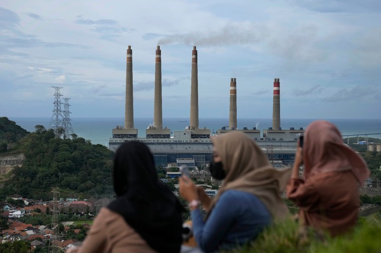 Warga duduk di bukit dengan pemandangan pembangkit listrik tenaga batu bara Suralaya di Cilegon, Banten, 8 Januari 2023. [Dita Alangkara/AP]