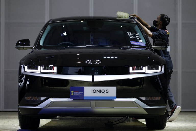 Seorang pekerja membersihkan mobil listrik Hyundai IONIQ 5 di acara Indonesia International Motor Show di Jakarta, 16 Februari 2023. [Willy Kurniawan/Reuters]