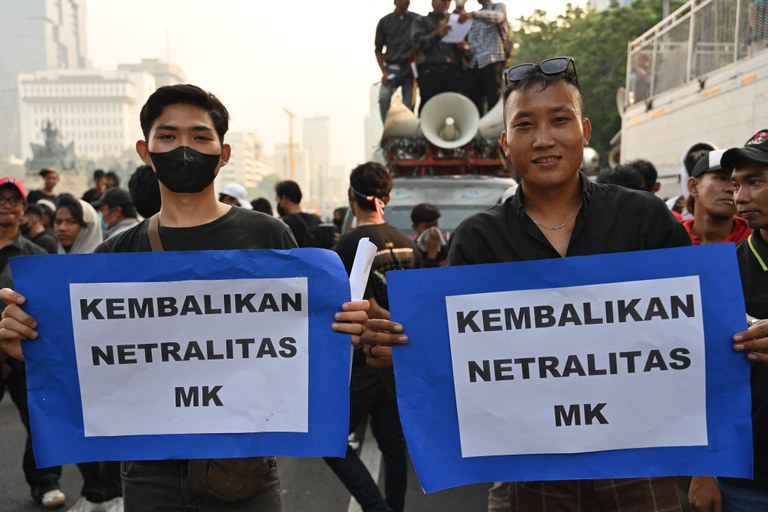 Aktivis memegang poster saat melakukan protes terhadap keputusan Mahkamah Konstitusi yang merubah peraturan batas minimum umur kandidat presiden/wakil presiden yang memuluskan pencalonan Gibran Rakabuming Raka, putra Presiden Joko Widodo, menjadi cawapres mendampingi capres Prabowo Subianto yang juga adalah menteri pertahanan, di Jakarta, 26 Oktober 2023. [Adek Berry/AFP]