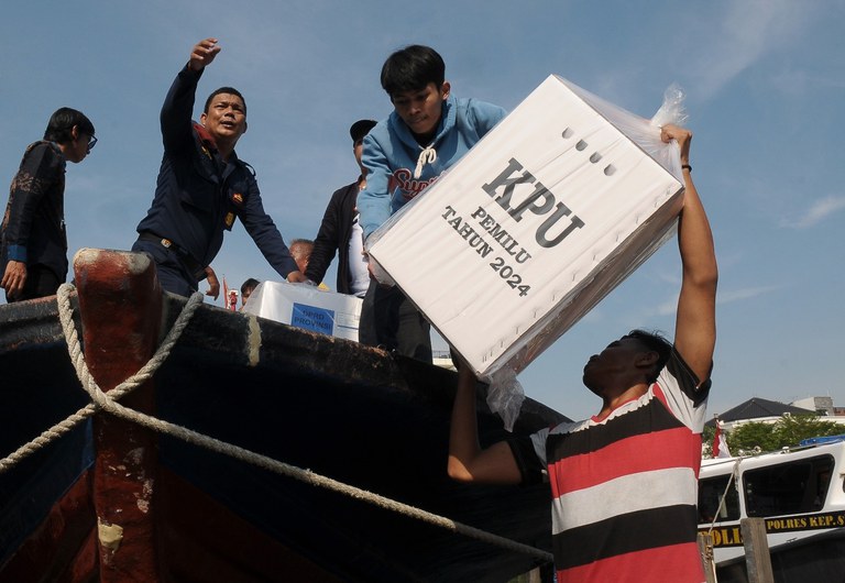 Petugas Kelompok Panitia Pemungutan Suara (KPPS) mengangkat logistik Pemilu 2024 yang akan didistribusikan ke Kepulauan Seribu di Pelabuhan Marina Ancol, Jakarta, Jumat, 9 Februari 2024. KPU Kabupaten Kepulauan Seribu mulai mendistribusikan sebanyak 22.515 surat suara dan 320 kotak suara menggunakan kapal tradisional ke gudang logistik di Pulau Pramuka. [Eko Siswono Toyudho/BenarNews]