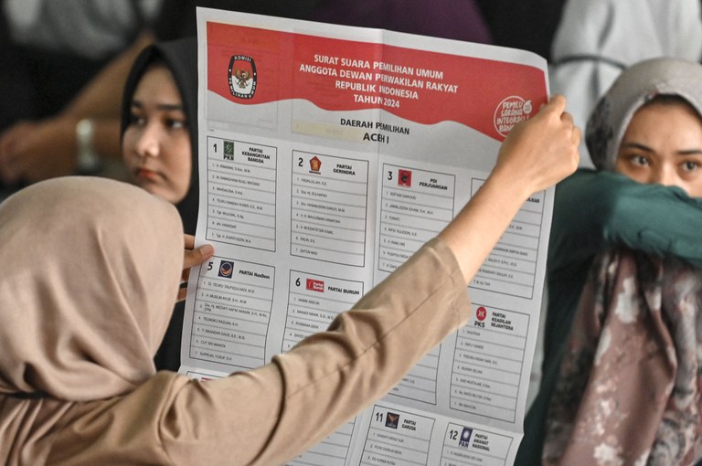 Para pekerja menyiapkan surat suara menjelang pemilu minggu depan, di Banda Aceh, 7 Januari 2024. [Chaideer Mahyuddin/AFP]