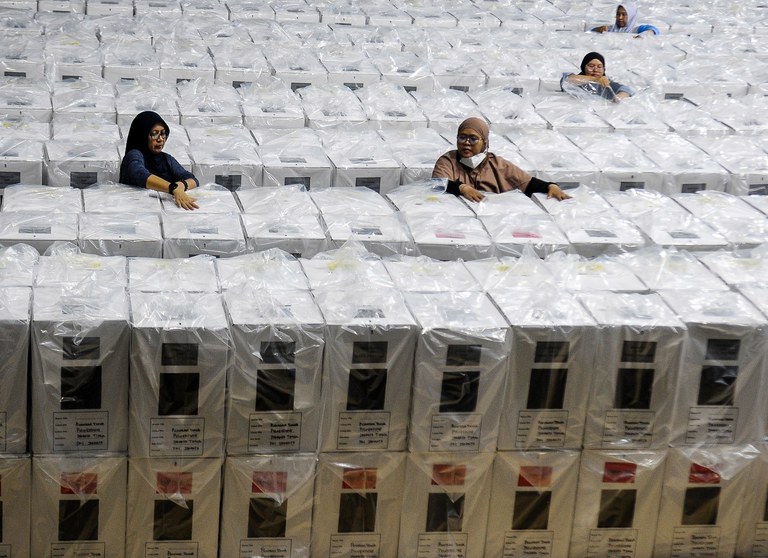 Petugas Kelompok Panitia Pemungutan Suara (KPPS) membawa Kotak Suara Pemilu 2024 di gudang logistik KPU Jakarta Pusat, GOR Cempaka Putih, Jakarta, 9 Februari 2024. [Eko Siswono Toyudho/BenarNews]