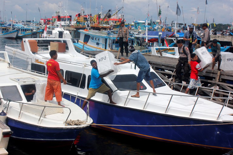 Para petugas mengangkat kotak suara ke atas kapal untuk didistribusikan di Sorong, Papua Barat, 16 April 2019. [Olha Mulalinda/Antara Foto/via Reuters]