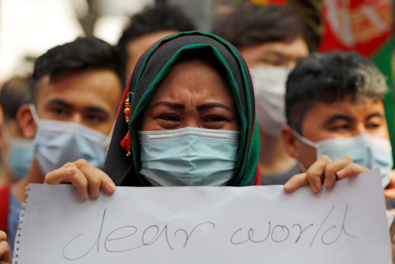 Seorang perempuan Afghanistan membentangkan sebuah poster dalam unjuk rasa  di luar gedung Badan Pengungsi PBB (UNHCR) di Jakarta, 24 Agustus 2021. [Reuters]