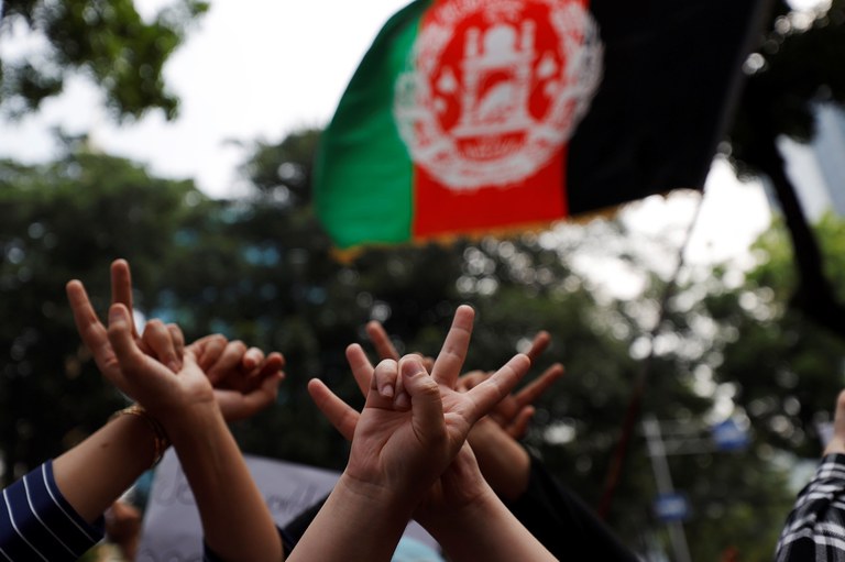 Para pengungsi Afghanistan memperlihatkan isyarat tangan dalam unjuk rasa meminta keadilan dan pemukiman kembali, di luar kantor UNHCR di Jakarta, 24 Agustus 2021. [Reuters]