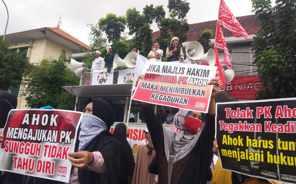Massa penentang Ahok membawa poster dan berorasi di luar Pengadilan Negeri Jakarta Utara, 26 Februari 2018. (Rina Chadijah/BeritaBenar)
