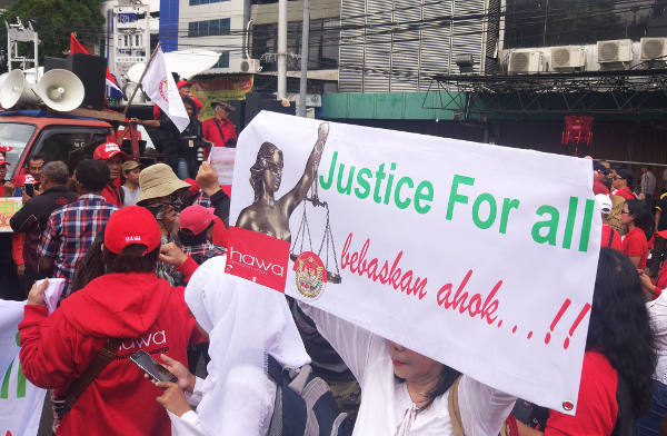 Massa pendukung Ahok berorasi dan membawa poster saat menggelar unjuk rasa di luar Pengadilan Negeri Jakarta Utara, 26 Februari 2018. (Rina Chadijah/BeritaBenar)