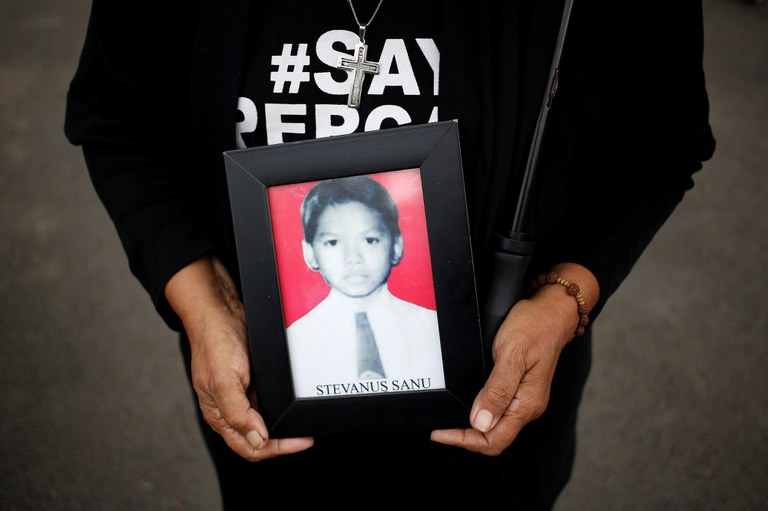 Maria Sanu, memegang potretnya putranya, Stevanus Sanu, 16 tahun, yang meninggal dalam kerusuhan Mei 1998, dalam aksi Kamisan di luar Istana Presiden di Jakarta, 12 April 2018. [Willy Kurniawan/Reuters]