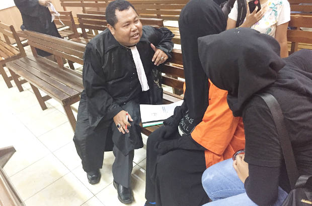 Terdakwa kasus terorisme Dita Siska Millenia (pakaian oranye) berbincang dengan kuasa hukum (kiri) seusai persidangan di Pengadilan Negeri Jakarta Utara, 5 November 2018. (Arie Firdaus/BeritaBenar)