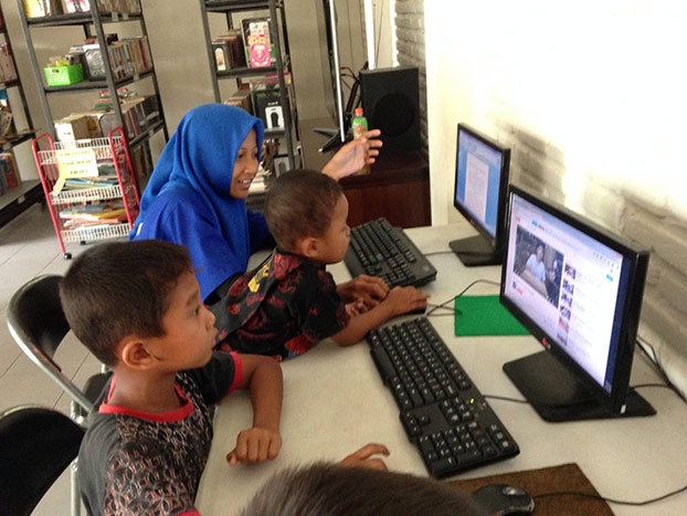 Riski Solikhah (berkerudung) dan Avi (tengah) sedang menggunakan fasilitas internet di PKBM, di Klaten, Jawa Tengah. (BeritaBenar)