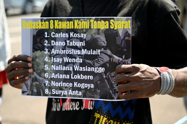 Seorang aktivis Papua membawa poster tuntutan pembebasan sejumlah rekannya yang ditangkap aparat keamanan dalam sebuah unjuk rasa di Denpasar, Bali, 6 September 2019. (AFP)  