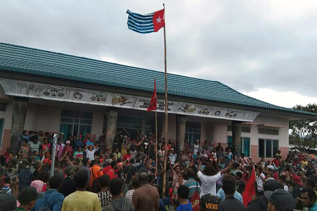 Para pengunjuk rasa berkumpul di bawah kibaran bendera Bintang Kejora yang dilarang pemerintah Indonesia, di Fakfak Papua, 21 Agustus 2019. [AFP]