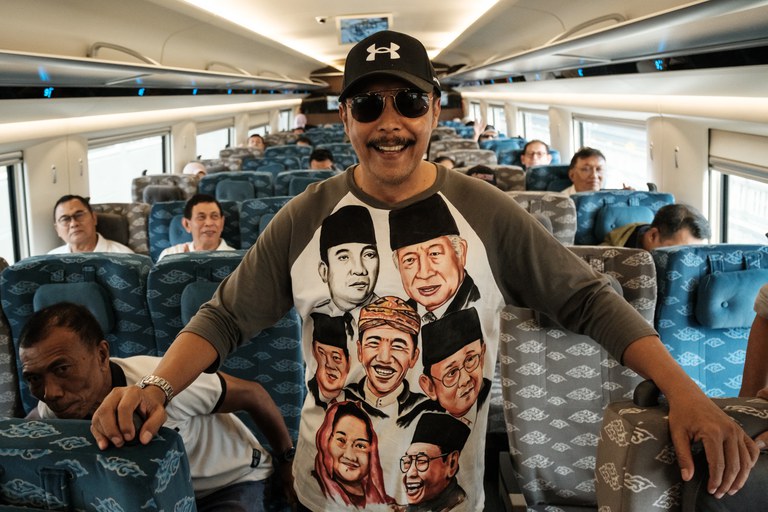 Seorang penumpang yang mengenakan kaus bergambar para presiden Indonesia, berpose di atas kereta cepat Jakarta-Bandung saat tahap uji coba publik kereta kerjasama dengan China itu di Bekasi, Jawa Barat, pada 17 September 2023. [Yasuyoshi Chiba/AFP]
