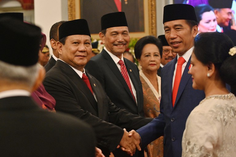 Presiden Indonesia Joko Widodo (kanan) berjabat tangan dengan Prabowo Subianto, yang ditunjuknya sebagai menteri pertahanan, saat upacara pelantikan di Istana Negara di Jakarta, 23 Oktober 2019. [Adek Berry/AFP]