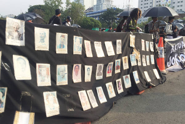 Peserta Aksi Kamisan memajang foto-foto korban pelanggaran HAM saat menggelar aksi di depan Istana Merdeka, Jakarta, 31 Mei 2018. (Nisita Kirana Pratiwi/BeritaBenar)