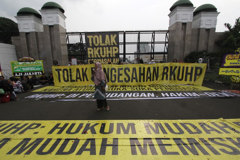 Seorang aktivis berpidato dalam unjuk rasa menentang pengesahan Rancangan Kitab Undang-Undang Hukum Pidana (RKUHP) yang dinilai mengandung pasal kontroversial terkait intervensi negara terhadap kehidupan privat masyarakat dan kriminalisasi atas kebebasan berpendapat, di depan Gedung DPR, di Jakarta, 5 Desember 2022. [Eko Siswono Toyudho/BenarNews]
