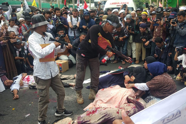   Sejumlah pengunjuk rasa mengelar aksi teaterikal penyiksaan warga Muslim Uighur saat melakukan aksi protes damai di depan Kedubes China di Jakarta, 21 Desember 2018. (Rina Chadijah/BeritaBenar)
