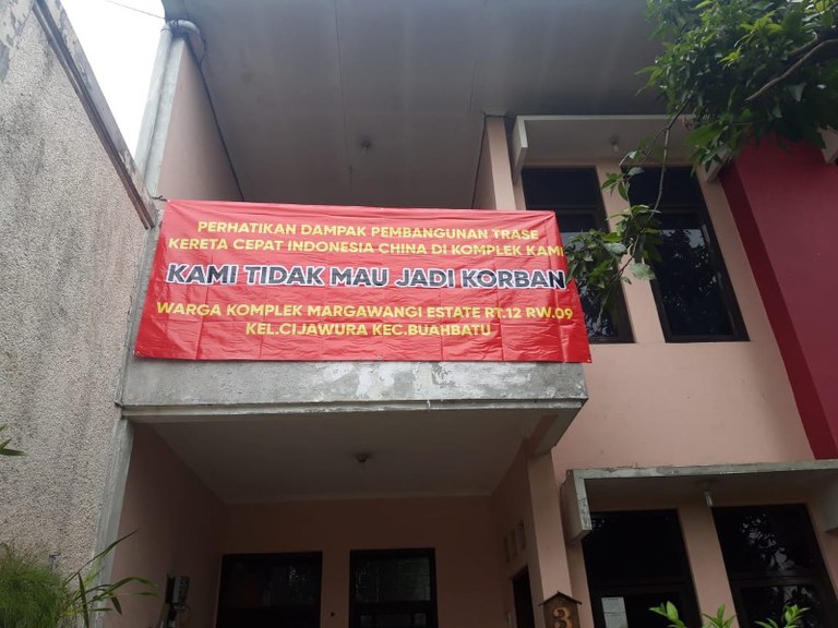 Sebuah spanduk di rumah salah seorang warga di perumahan Margawangi Estate di Kota Bandung yang lokasinya berada di dekat proyek kereta cepat Jakarta-Bandung. [Dok. Sri Rama Aryadhana]