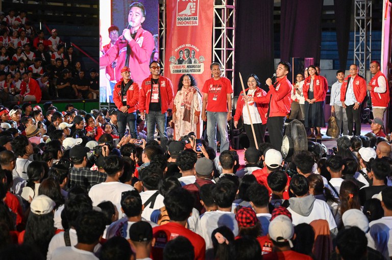 Kaesang Pangarep (tengah), Ketua Umum Partai Solidaritas Indonesia (PSI) dan putra bungsu Presiden Joko Widodo, berbicara saat acara kampanye mendukung pasangan  Prabowo Subianto dan Gibran Rakabuming Raka, yang juga adalah kakak Kaesang, dalam  Pemilihan Presiden 2024, di Gelanggang Olahraga Ngurah Rai di Denpasar pada 5 Februari 2024. [Sonny Tumbelaka/AFP ]