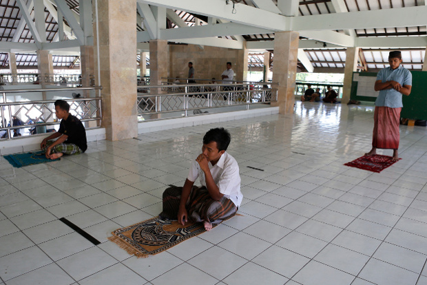 Warga Muslim melakukan jaga jarak sosial sebagai pencegahan penularan COVID-19 ketika melakukan shlat Jumat di sebuah mesjid di Bali, Indonesia, pada 20 Maret, 2020. (AP) 