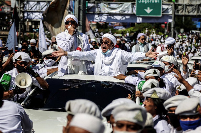 Kerumunan menyambut kedatangan Rizieq Shihab ketika ia meresmikan sebuah masjid di Bogor, Jawa Barat, tiga hari setelah ketibaannya di Tanah Air dari pengasingannya di Arab Saudi, 13 November 2020. [AFP]