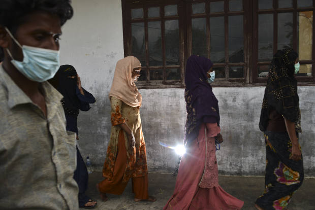 Sejumlah pengungsi Rohingya mengantri setelah melakukan proses identifikasi di tempat penampungan mereka di bekas Kantor Imigrasi Lhokseumawe, Aceh, 26 Juni 2020. [AFP]