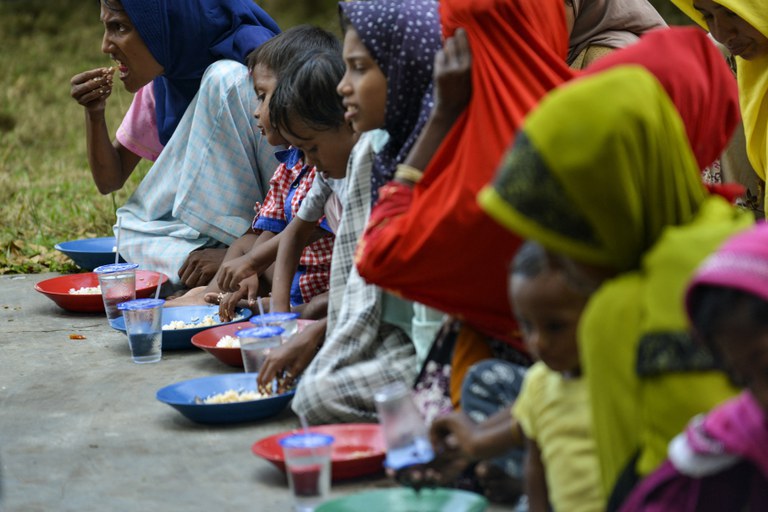 Pengungsi Rohingya makan di tempat penampungan sementara setelah kedatangan mereka dengan perahu di Laweueng, Pidie, Aceh, 27 Desember 2022. [Chaideer Mahyuddin/AFP]