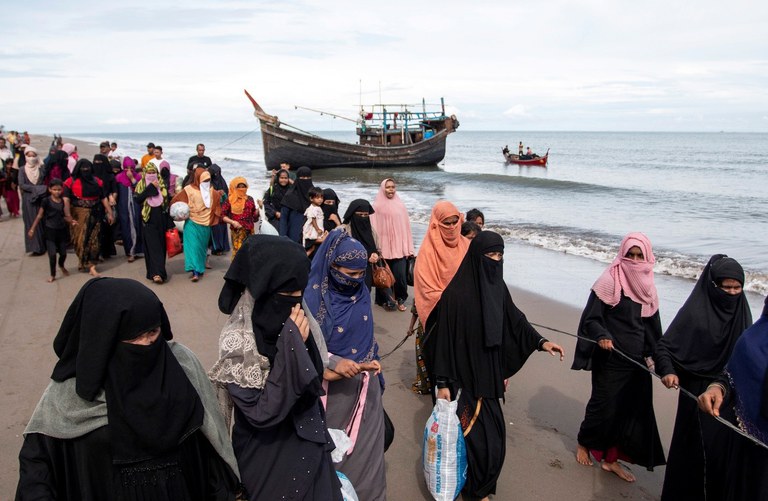 Orang-orang Rohingya berjalan ke tempat penampungan sementara setelah perahu kayu mereka mendarat di Aceh Utara, 16 November 2022. [Zik Maulana/AP]