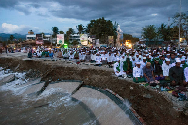 Warga mengadakan salat bersama di Palu pada 12 Oktober 2018, dua minggu setelah terjadinya gempa dan tsunami pada 28 September yang menewaskan 2.000 orang dan ribuan orang dinyatakan masih hilang. (AFP)