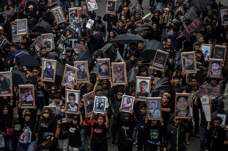 Membawa foto-foto korban yang meninggal, warga berunjuk rasa di depan Balai Kota Malang pada 10 November 2022, menuntut Persatuan Sepak Bola Seluruh Indonesia (PSSI) bertanggung jawab, adil dan transparan dalam melakukan investigasi menyusul insiden maut di Stadion Kanjuruhan pada 1 Oktober 2022 yang memakan 135 korban jiwa. [Juni Kriswanto/AFP]