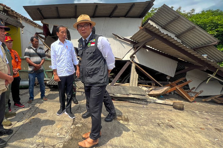 Presiden Joko Widodo didampingi Gubernur Jawa Barat Ridwan Kamil (kanan) dan sejumlah pejabat lainnya berada di Cianjur setelah gempa berkekuatan 5,6 yang menewaskan sedikitnya 260 orang dan sekitar 150 orang lainnya masih dinyatakan hilang, menimpa wilayah tersebut sehari sebelumnya. [Handout/Istana Kepresidenan/AFP]