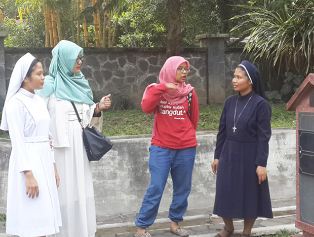 Anggota Srikandi Lintas Iman dan seorang suster melihat kuburan di komplek ST Caralus Borromeus Yogyakarta, 3 Juni 2017. (Kusumasari Ayuningtyas/BeritaBenar)