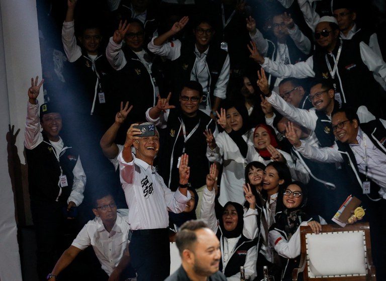 Ganjar Pranowo, calon presiden dari Partai Demokrasi Indonesia Perjuangan berfoto bersama para pendukungnya dengan memperlihatkan salam 3 jari pada saat debat para kandidat presiden yang disiarkan televisi di Komisi Pemilihan Umum di Jakarta, 12 Desember 2023. [Ajeng Dinar Ulfiana/Reuters]